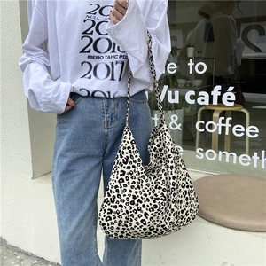 Detail of a large leopard print canvas tote bag shown during an outdoor street shoot