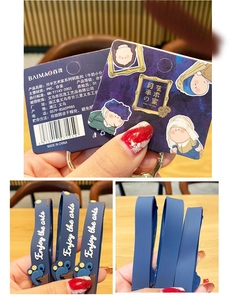 Detail of blue PVC artist keychain with Enjoy the arts text and themed packaging tag