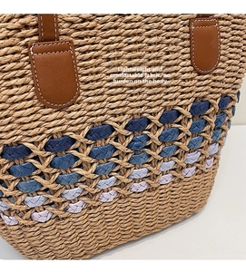 Close-up of woven straw texture with colorful striped bands and leather stitch details