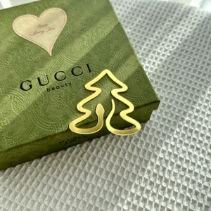 Close-up of golden acrylic Christmas cake topper on a luxury textured gift box