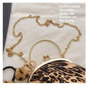 Detail of leopard print shell bag featuring a gold chain strap and vintage metal handle