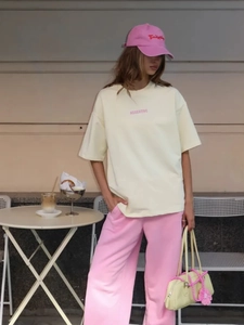 Dettaglio di una t-shirt in cotone giallo chiaro stampata e pantaloni casual rosa da strada