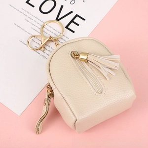 Detail of mini backpack coin purse with cream lychee pattern PU leather and tassel