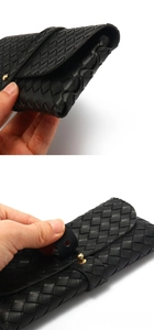 Détail de la texture en cuir tressé noir et fermoir sphérique doré pour étui à lunettes