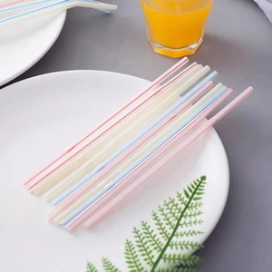 Flexible disposable plastic straws with colorful stripes for beverages on a white plate