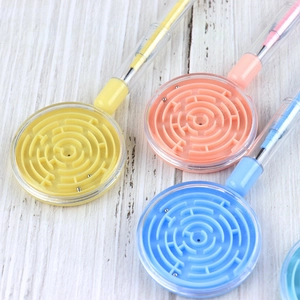Detail of creative ballpoint pens with built-in mini maze puzzles and colorful plastic barrels