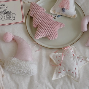 Detailed view of pink plush Christmas ornaments with striped trees and stars