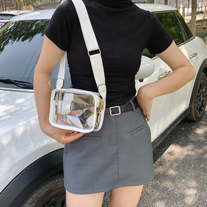 Detailed shot of transparent PVC crossbody bag with wide strap and floral silk scarf detail