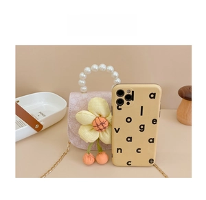 Pink pearl handle bag size comparison with a phone and yellow flower detail