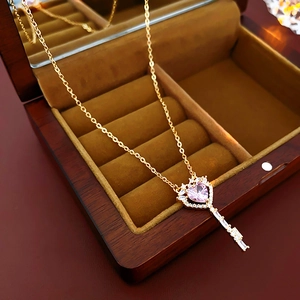 Detail der Gold-Schlüsselkette mit rosa Herz-Edelstein und Zirkonen im Schmuckkästchen