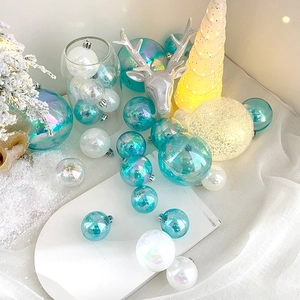 Iridescent blue and pearl white Christmas ball ornaments set on snowy display