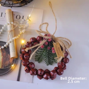 Détail d'une couronne de Noël avec des cloches rouges et un panneau Joyeux Noël