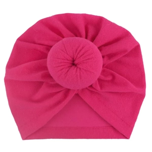 Close-up of baby donut turban hat in rose red soft fabric with detailed donut knot