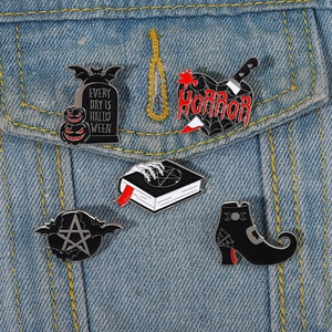 Detail view of 5-piece spooky enamel pins set pinned on a denim jacket pocket