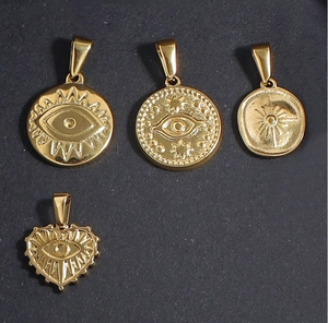 Detail of 24K gold plated evil eye and sunburst charms in round and heart shapes