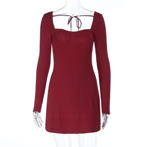 Detail of burgundy knitted mini dress showing ribbed texture and corset-style bust design
