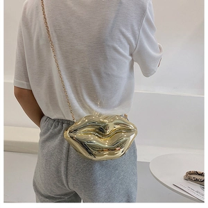 Close-up of a metallic gold lip-shaped crossbody bag with a sleek chain strap