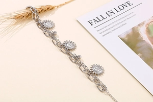 Detail of silver double-layer sun pendant bracelet with vintage sunburst charms and chains