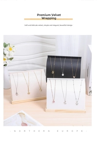 Three-tier velvet necklace display stands in beige, black and white on wooden bases