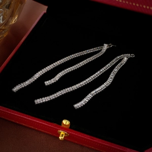 Detail of square zircon long fringe earrings with silver needle on black velvet