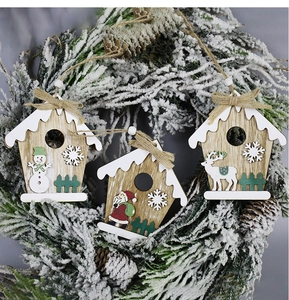 Detailed view of wooden Santa, Snowman and Reindeer ornaments on a festive pine wreath