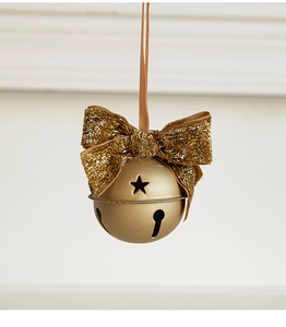 Detail of golden Christmas bell with glittery bow and star cutouts on white background