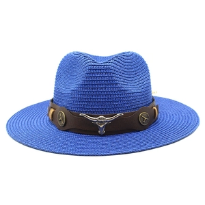Close-up of bright blue straw cowboy hat with brown leather band and silver bull head detail