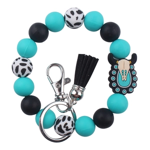 Detail of beaded silicone wristlet keychain with black tassel and cow skull charm