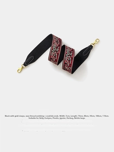 Close-up of 5cm black paisley embroidered bag strap with leather ends and gold hardware