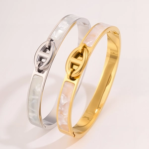 Macro detail of pig nose oval buckle and pearlescent shell inlay on stainless steel bracelets
