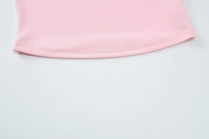 Macro detail of high-quality pink ribbed knit fabric with reinforced double-stitch hemline
