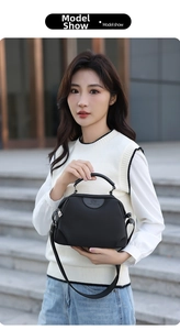 Modern black waterproof oxford handbag with adjustable strap shown on model outdoors