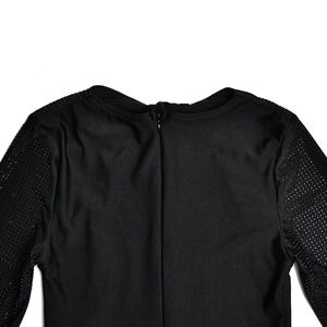 Détail d'une robe moulante noire avec fermeture éclair invisible et manches en mesh pailleté