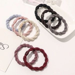 Detailed view of colorful twisted elastic hair ties scattered on a decorative white plate