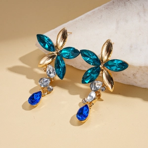 Détail de boucles d'oreilles vintage fleurs à pétales bleu paon et cristaux en goutte