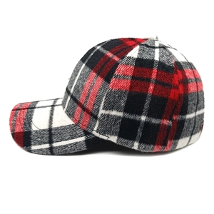Dettaglio della trama in lana scozzese rossa e nera e delle cuciture del cappello