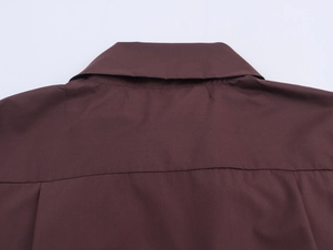 Detailed close-up of the back neckline and fine fabric texture on a maroon blouse
