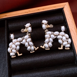 Macro view of vintage poodle earrings with pearl inlay and crystals on gold metal base