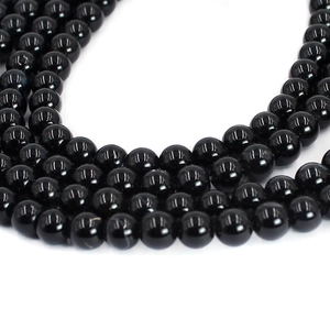 Macro close-up showing polished natural black agate round beads for DIY jewelry making