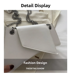 Detail of white geometric chain bag showing smooth faux leather texture and silver hardware