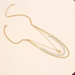 Multilayer gold chain necklace with turquoise beads and a round sunburst pendant