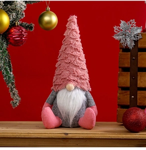 Detail of pink and grey plush Christmas gnome doll with faux beard on a festive red background