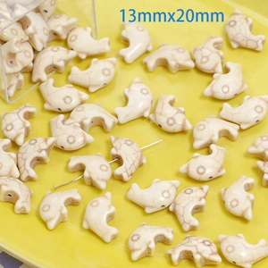 Detail of dolphin-shaped white turquoise beads with natural texture, size 13mmx20mm