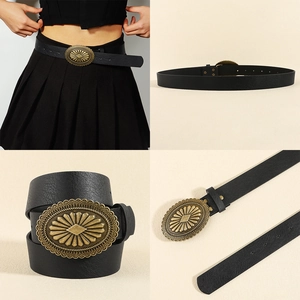 Detail of vintage black leather belt with gold sunburst engraved oval metal buckle