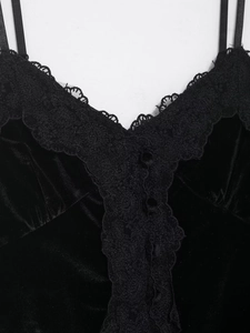 Detail eines schwarzen Samt-Tops mit Spitzenbesatz am Ausschnitt und Zierknöpfen