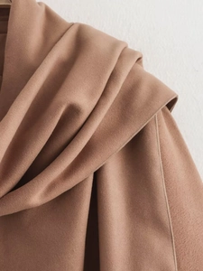 Gros plan du tissu en laine mélangée camel avec coutures précises et plis texturés