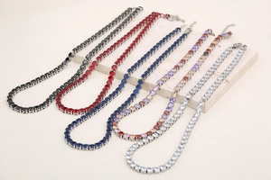 Detail of 18K gold plated tennis necklaces with multi-color zircon stones on stone display