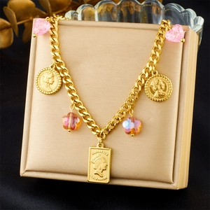 Detailed macro view of gold-plated bracelet with pink crystal hearts and coin charms