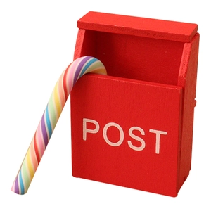 Miniature red wooden dollhouse post box with POST text and candy cane on white background