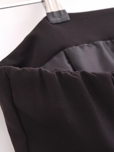 Detail of black midi dress showing elastic gathered waist and twill fabric texture